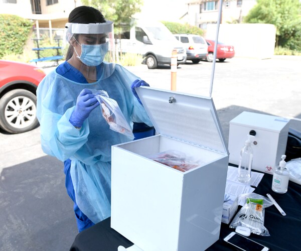 a healthcare worker handles coronavirus test samples