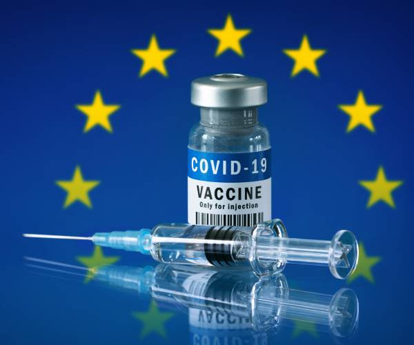covid vaccine in front of a european union flag