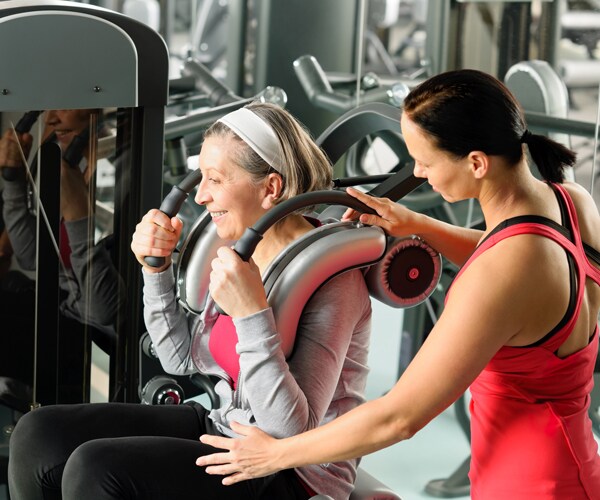 a woman works with a trainer at the gym