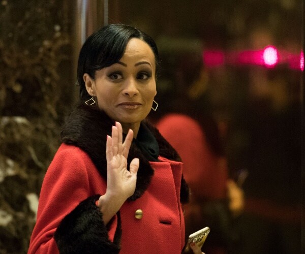 pierson in a red coat waving 