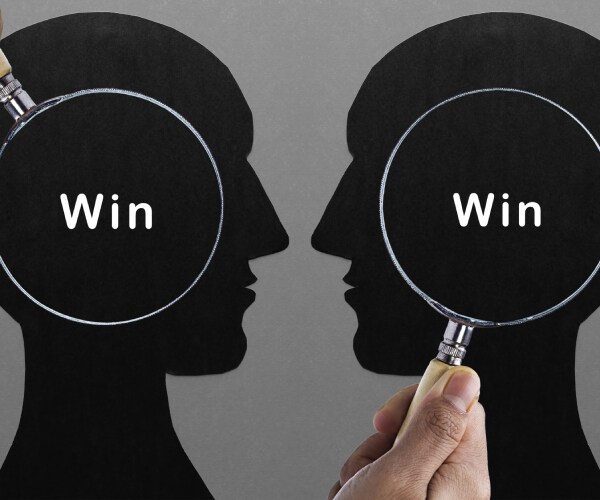 two profile heads with win written on both and magnifying glasses over them