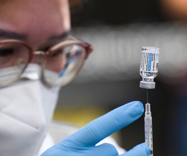 nurse prepares vaccine syringe