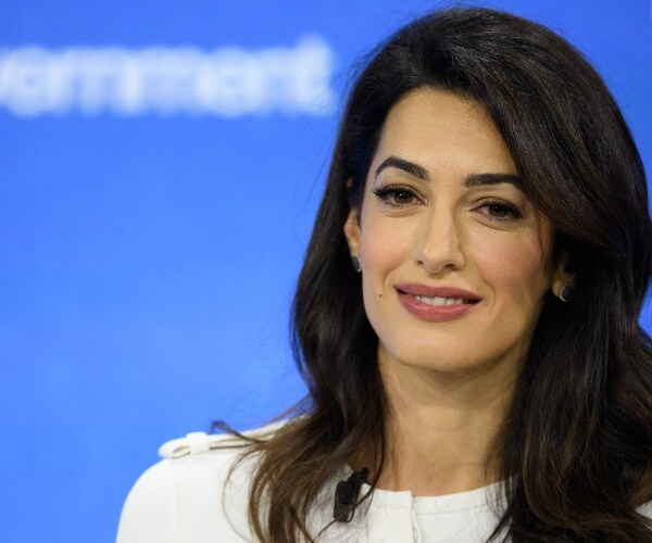 clooney in a white dress with blue backdrop