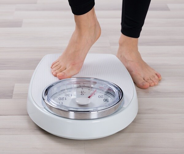 person steps onto scale