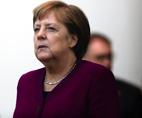 angela merkel walks out of a summit meeting