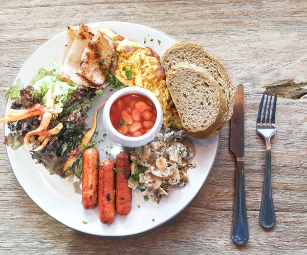 breakfast plate full of eggs, beans, bread, and more, viewed from above 
