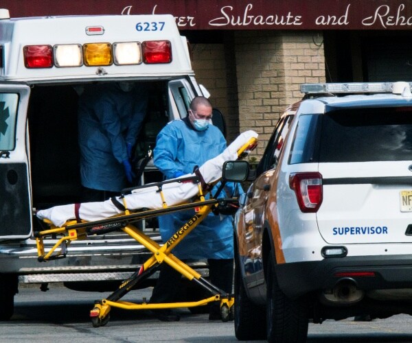 medical workers wearing blue protective suits and face masks prepare a stretcher for nj nursing home morgue