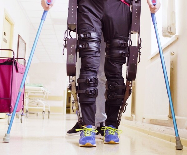 man using a robotic exoskeleton to walk