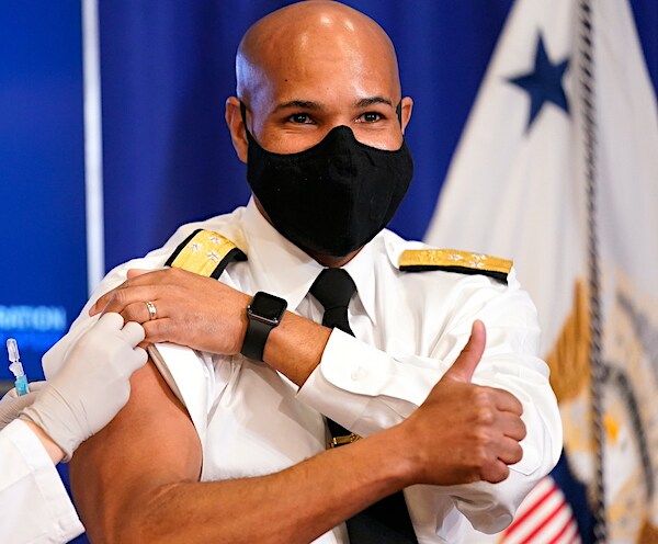 jerome adams gives a thumbs up as he receives the first dose of the moderna vaccine