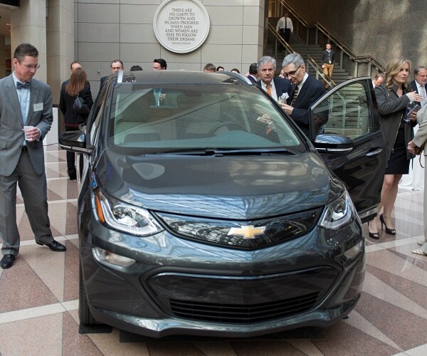 man looks at electric vehicle