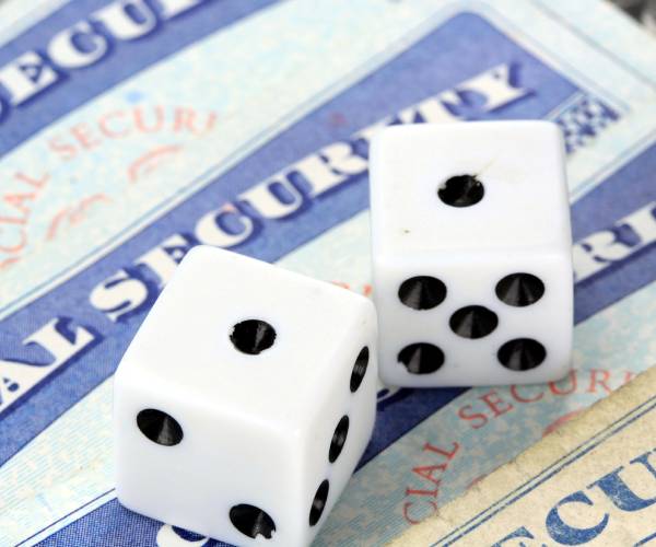 social security cards with two dice on top that have rolled two ones or snake eyes