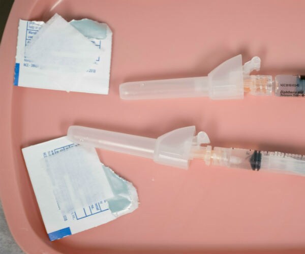 open alcohol swabs and syringes are shown