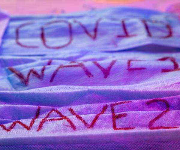 surgical masks with covid wave one and two written on them