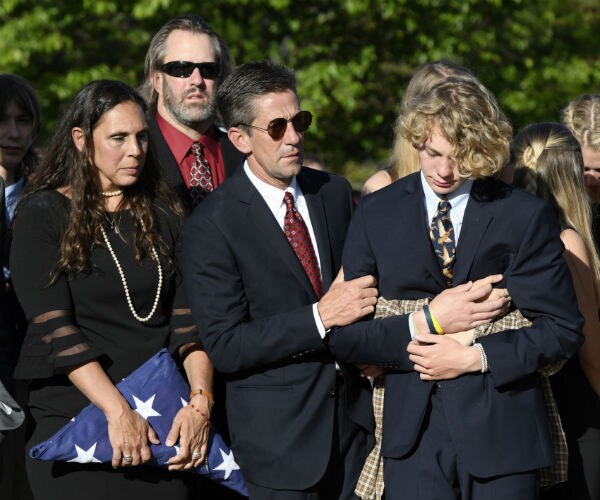 rarents of riley howell, stands next to thomas howell, comforting their son teddy, after a memorial service